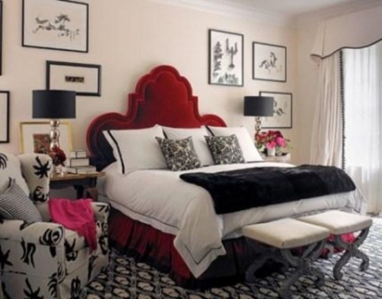 a neutral bedroom with a black and white printed rug, a printed chair, stained nightstands and black table lamps
