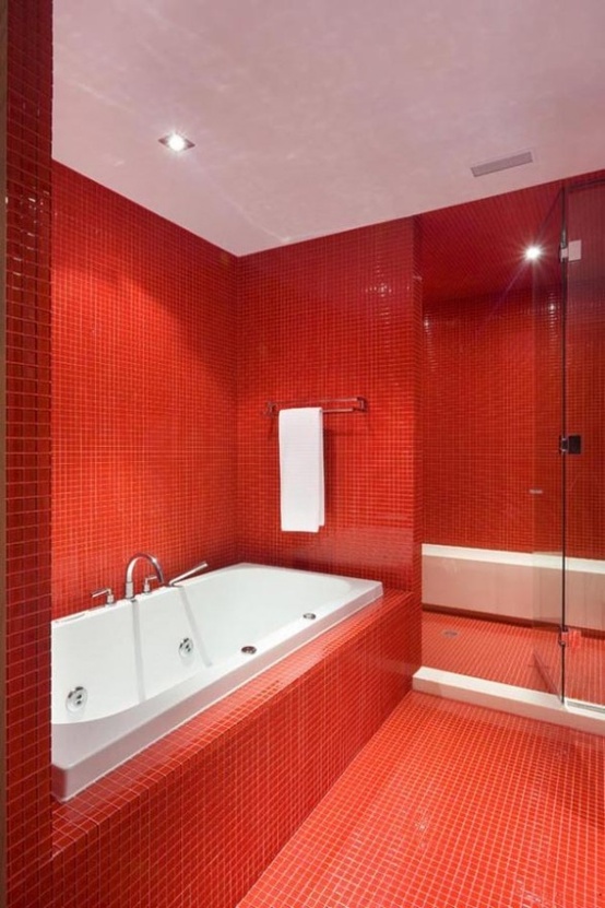 a bright red bathroom with white appliances and a white ceiling to refresh the space a little bit