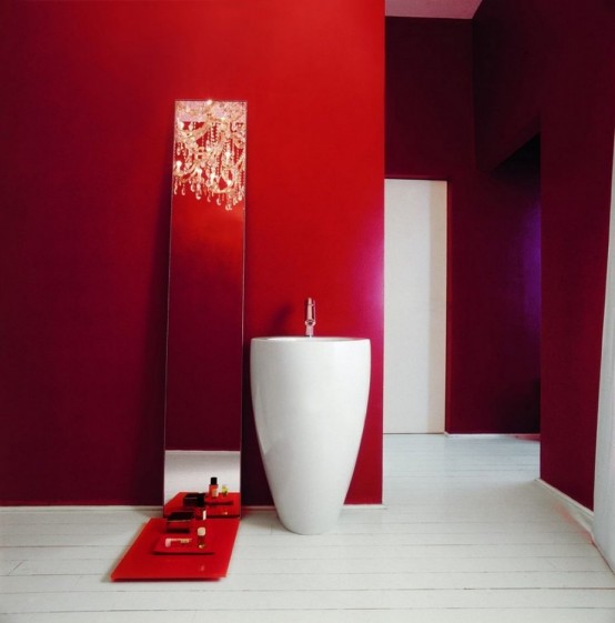 a unique minimalist bathroom in red, with a free-standing sink, a mirror with a shelf and a white floor