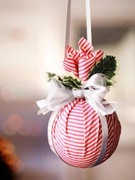 a red and white Christmas ornament decorated with greenery and a ribbon bow can be made very easily, just wrap a bauble with some fabric