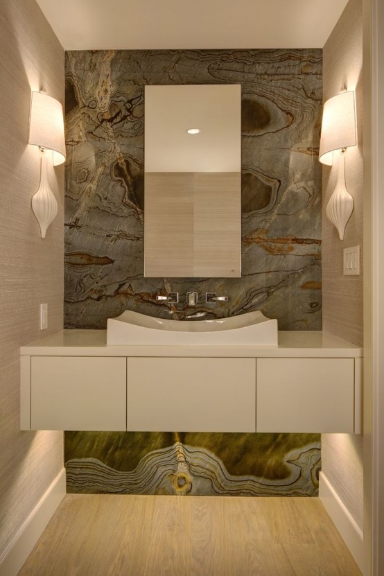 a neutral bathroom with a grey onyx accent wall, a built-in vanity and a sink, wall sconces looks luxurious and chic