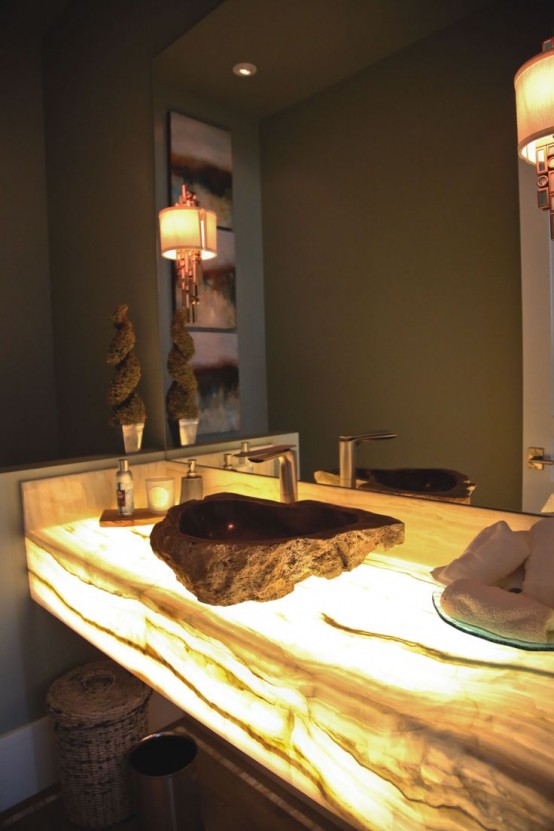 a neutral beige bathroom with a lit up onyx built-in vanity that makes the space eye-catchy and chic and bring interest to the space