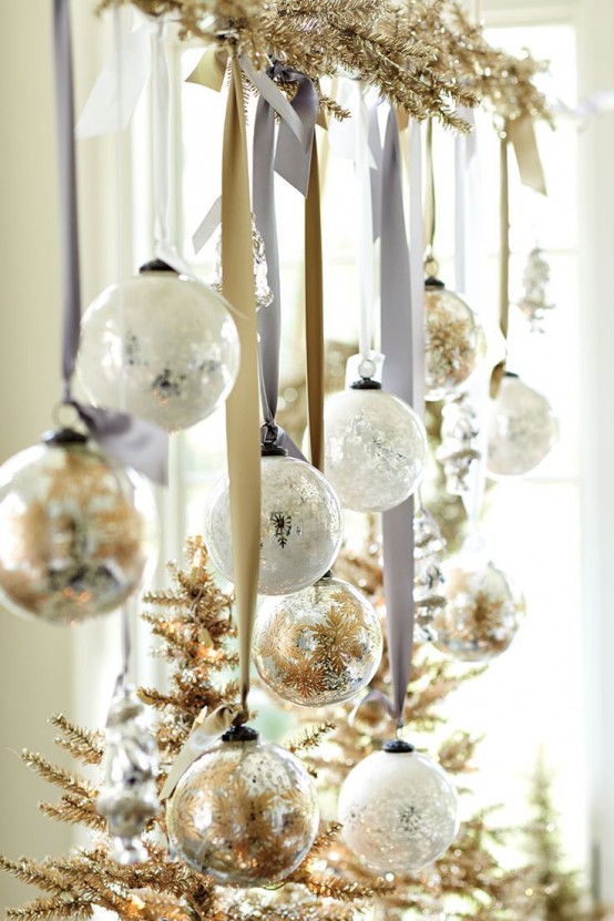 beautiful Christmas decor with a gilded evergreen branch, printed white and gold ornaments hanging on silk ribbons is pure chic and elegance