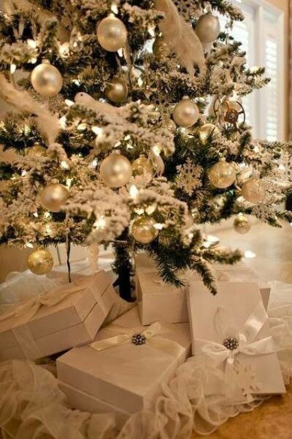 a refined Christmas tree with lights, pearly and gold ornaments, and fluffy garlands is amazing for a winter wonderland space