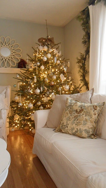 a Christmas tree decorated with white and gold ornaments, lights, snowflakes and snowball ornaments is amazing