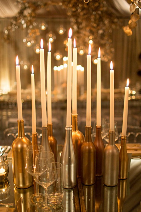 glossy silver and gold bottles as candleholders with thin and tall candles compose refined and chic Christmas decor