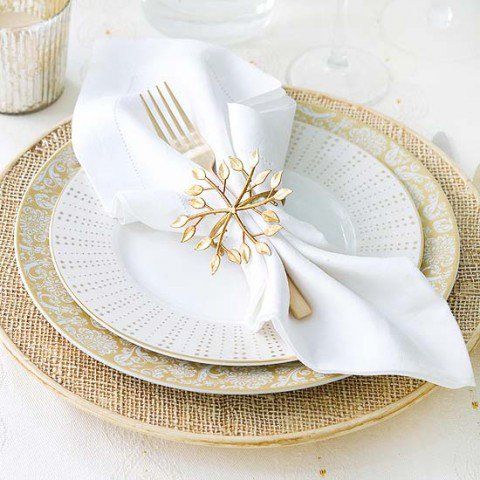 a woven placemat, gold and white plates, a white napkin with a gold snowflake napkin ring are all amazing for Christmas