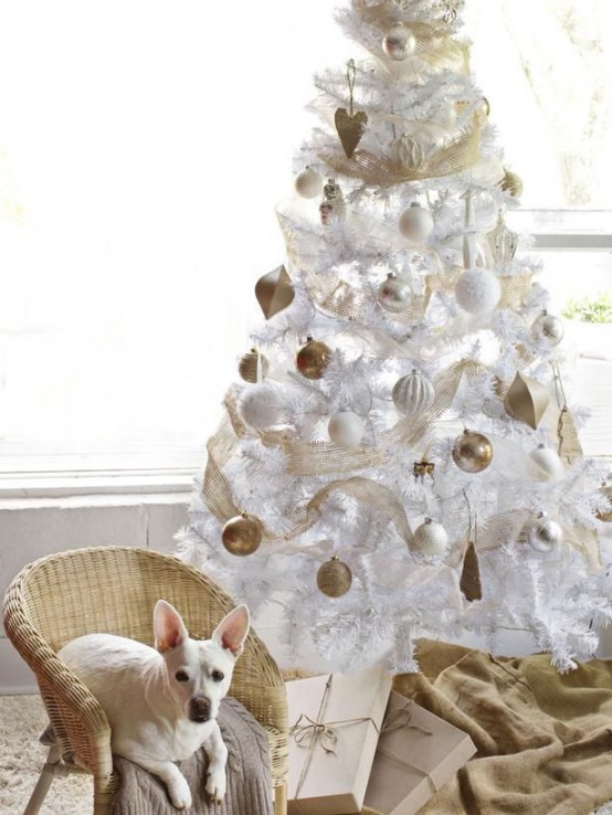 a white Christmas tree with white and gold ornaments, gold mesh ribbon is a chic and cool idea for a glam space