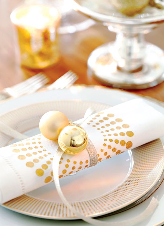 a white and gold polka dot plate, a white and polka dot napkin, gold ornaments are amazing for a chic Christmas place setting