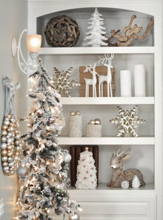 white and gold Christmas niche styling with gilded snowflakes, a mini tree with gold ornaments, a flocked Christmas tree with silver and gold ornaments and a wreath of them