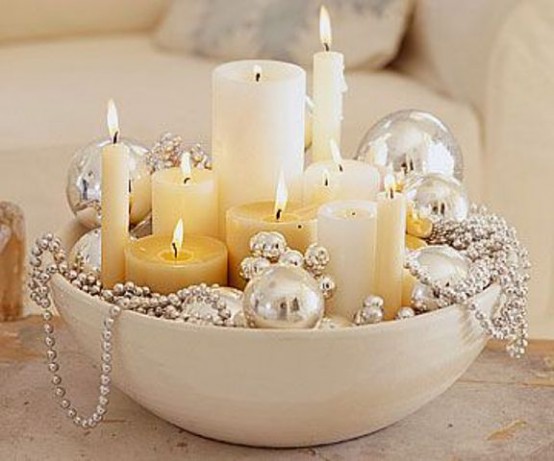 a large bowl with pillar and thin candles and gold ornaments and beads is a refined and chic Christmas decoration or centerpiece