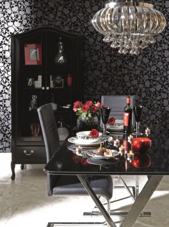 a modern Gothic dining room with skull wallpaper, a glass table, grey leather chairs, a glass armoire and a beautiful and shiny chandelier