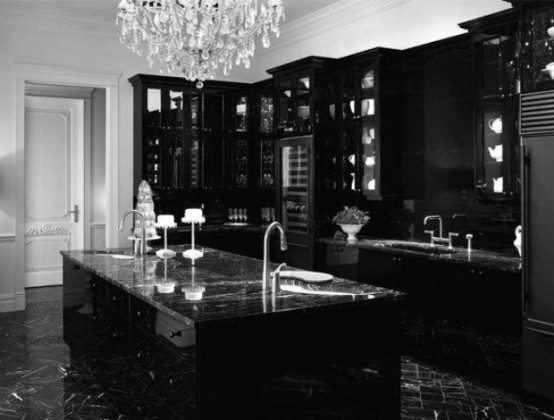 a fantastic black Gothic kitchen with modern cabinets, refined black marble countertops and a large crystal chandelier