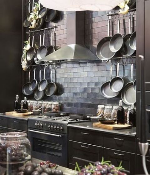 a chic dark kitchen with modern moody cabinetry, a shiny tile backsplash and a metal hood is a chic idea