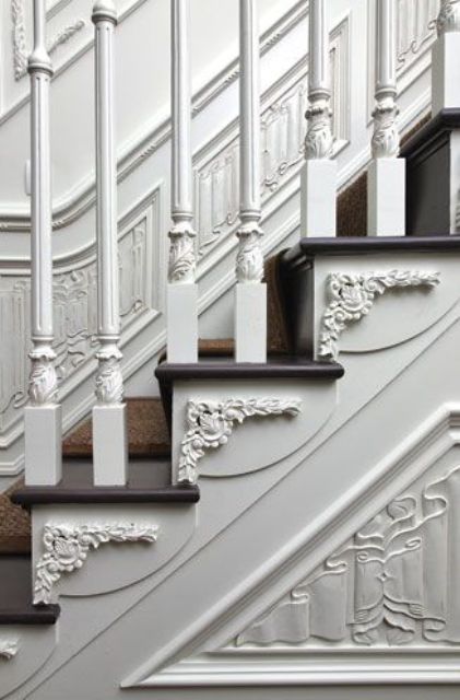 gorgeous molding on the walls, stairs and the railing makes this space super chic and beautiful and it looks very inspiring