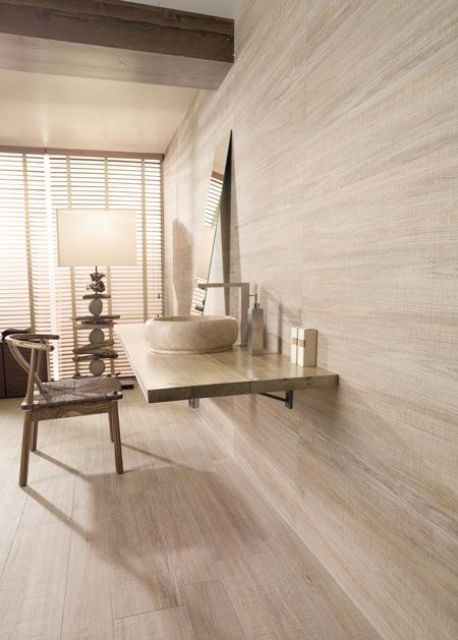 whitewashed wooden walls and a floor done with light colored laminate give a textural and light filled look to the space