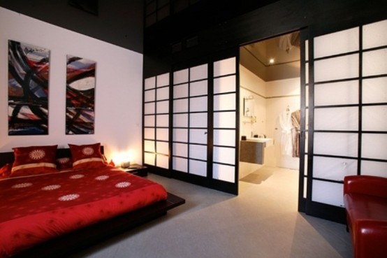 a bold Asian bedroom with a traditional zen feel, dark and red furniture, Asian sliding doors and bright bedding and a gallery wall in bright shades