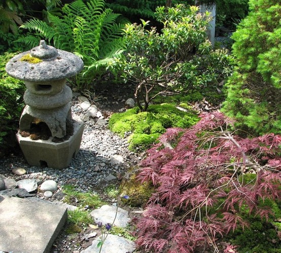 musgo, rocas, guijarros, arbustos, árboles pequeños y una linterna japonesa de piedra para un hermoso jardín japonés