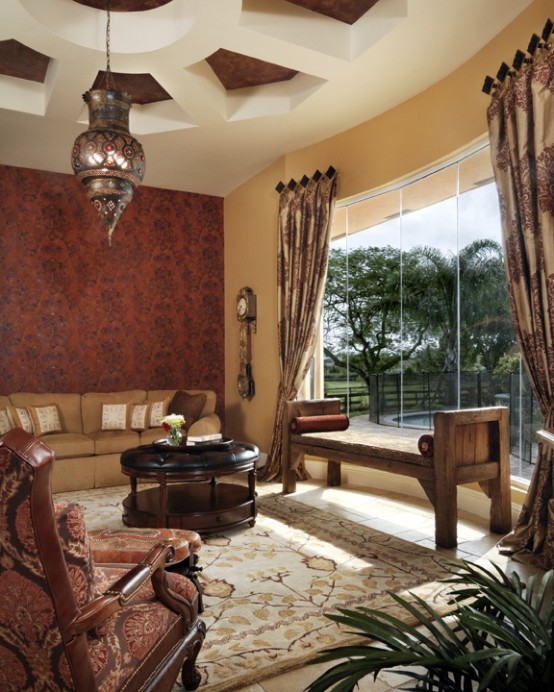 a muted tone Moroccan living room with an embellished pendant lamp, luxurious textiles and carved furniture