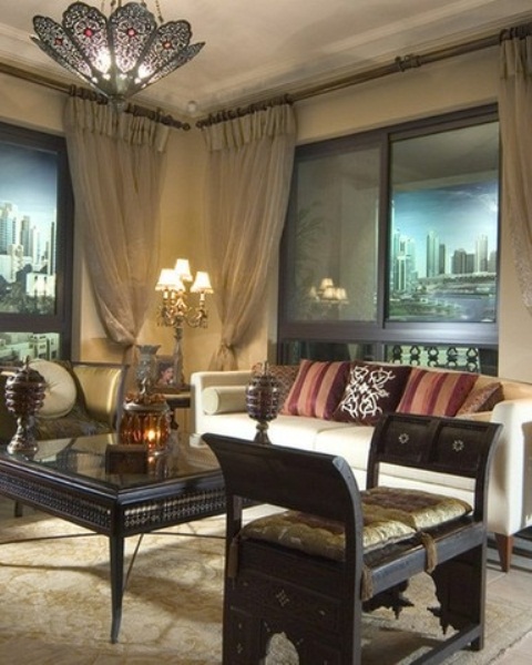 a neutral living room with carved furniture and embellished lamps on the ceiling