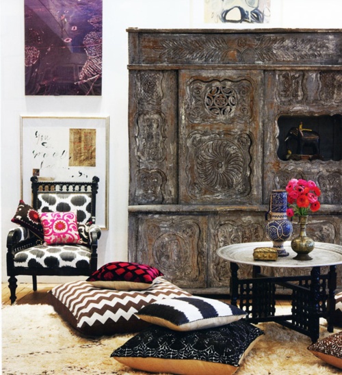 a neutral Moroccan living room with a stunning carved storage unit plsu colorful pillows