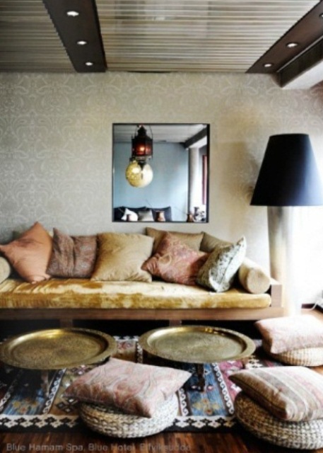a neutral Moroccan space with colorful and patterned textiles and traditional lamps