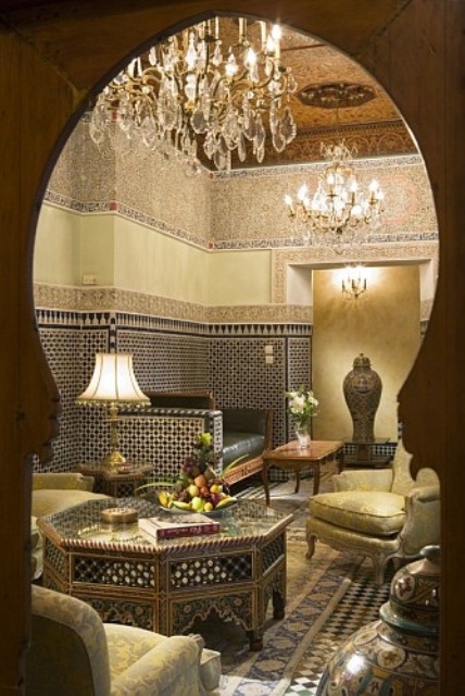 a formal Moroccan space in gold and black, with mosaics, carved furniture and tiles on the walls