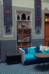 a bright Moroccan living room done with mosaic tiles, artworks and colorful furniture
