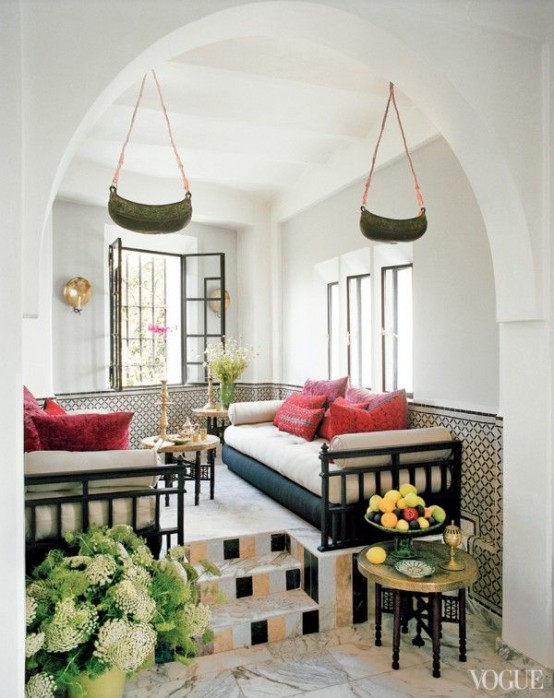 a neutral living room in an alcove, unique pendant lanterns and carved coffee tables