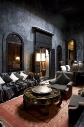 a dark and moody Moroccan space with orante doors and windows and a gorgeous metal coffee table