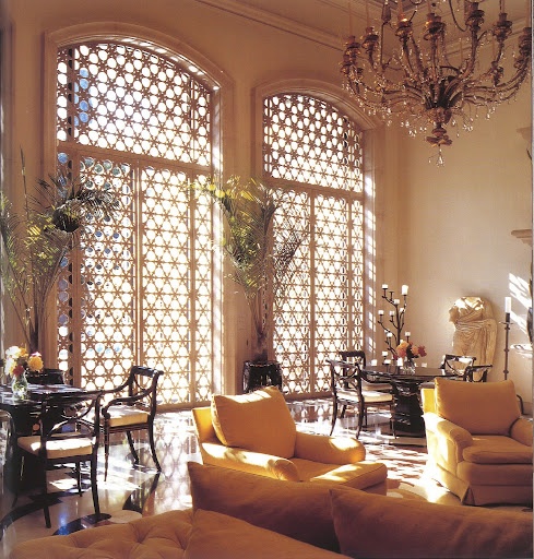 a neutral living room with gorgeous carved window screens that remind of Moroccan style