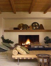 a neutral living room with carved chess by the fireplace and a carved coffee table that hint on Moroccan style