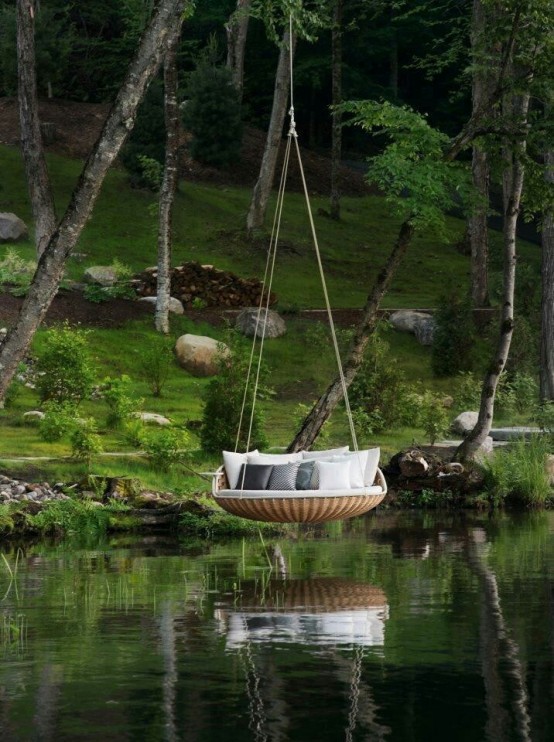 a round wicker bed hanging on ropes over a lake or pond is a cool way to get more relaxation from water, too