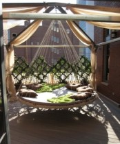 such a round outdoor hanging bed with ropes and pillows can accommodate several people, so it’s gonna be fun