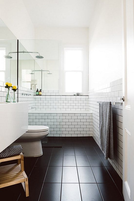 a Scandinavian bathroom in black and white, with natural wood and printed towels