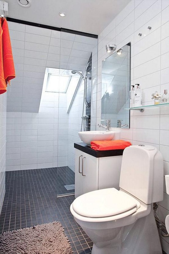 a black and white modern Nordic bathroom with red towels and a skylight for natural light in the shower