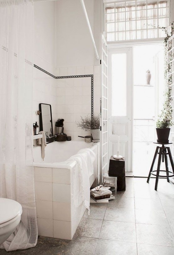 a vintage serene Scandinavian bathroom in white and grey, with vintage stools and potted greenery