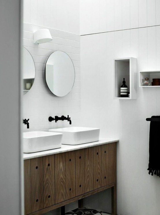 a simple Nordic bathroom done with white tiles, a wooden vanity and box shelves on the wall