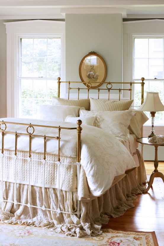 a neutral vintage bedroom with grey walls, a vintage metal bed, elegant nightstand and lamps