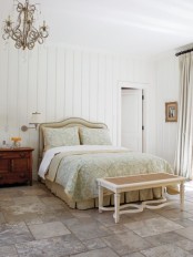 a neutral farmhouse feminine bedroom with refined furniture, with pastel textiles and a chic vintage chandelier is a beautiful space