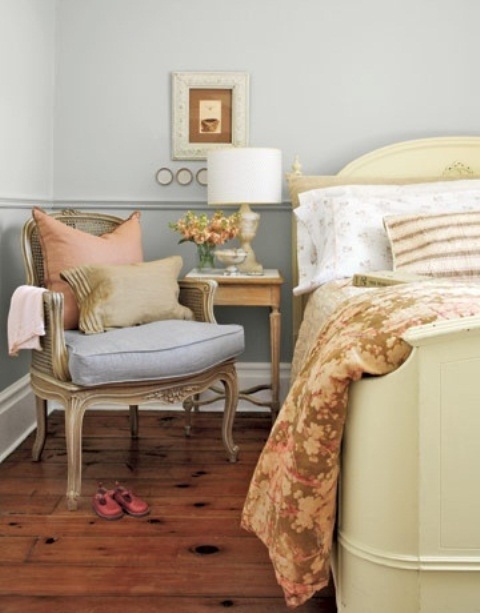 a welcoming powder blue bedroom with elegant vintage furniture, printed and solid bedding and a table lamp is chic and stylish