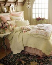 a romantic shabby chic bedroom with neutral walls, a neutral bed with floral and pink bedding, pretty artworks and a crystal chandelier plus a refined nightstand