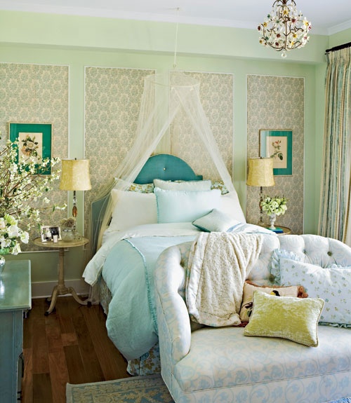 a refined feminine bedroom paneled walls, a blue upholstered bed and dresser, a floral loveseat and a florla chandelier is very refined and cool