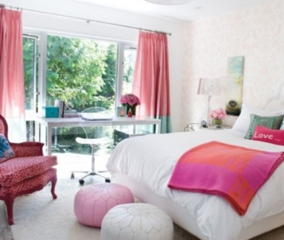a colorful contemporary bedroom with a pink chair, ottoman, blanket and color block curtains and bright touches to the white backdrop is wow