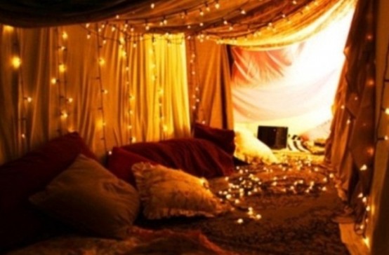 curtains with lights over the sleeping space is a cool idea for a bedroom