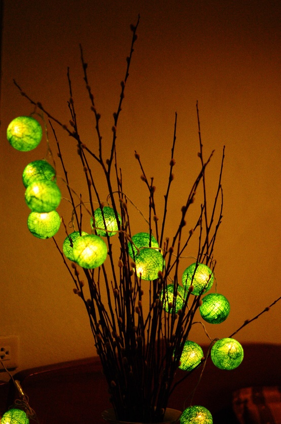a branch arrangement with green wrapped lights is a creative and unique idea