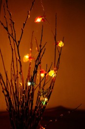 a branch arrangement with various catchy lights is a fun idea for a bedroom or another space