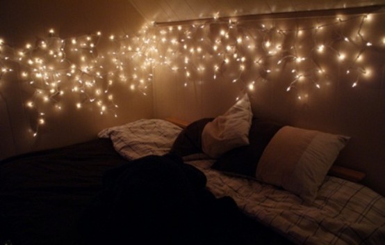 a canopy of lights over the bed is a cool and chic idea that is timeless