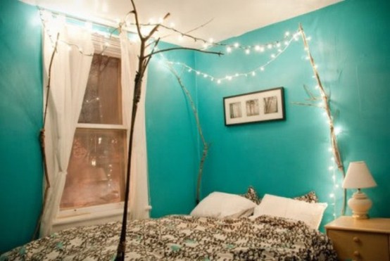 branches over the bed and lights hanging on them is a great relaxed idea for a bedroom