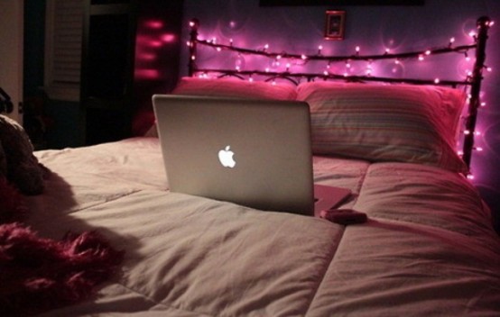 pink lights covering the headboard is a cute way to add light to the bedroom